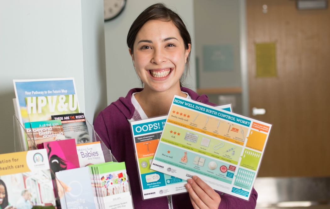 A young woman holding a contraceptive counseling chart