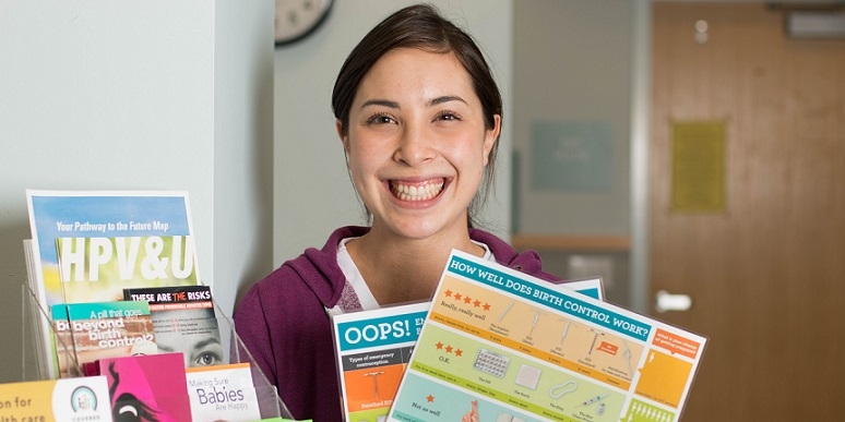 Patient holding birth control education charts.