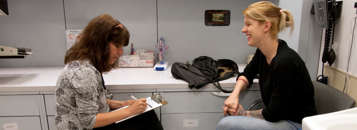 A provider talking to a patient in an exam room. 