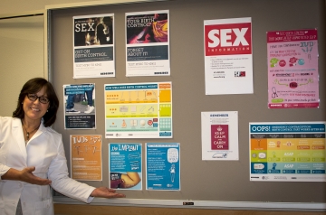 Provider standing next to bulletin board of educational posters