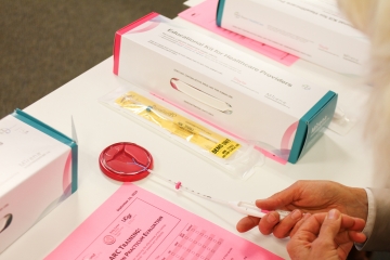 Provider practices inserting an IUD into a plastic demo model. 